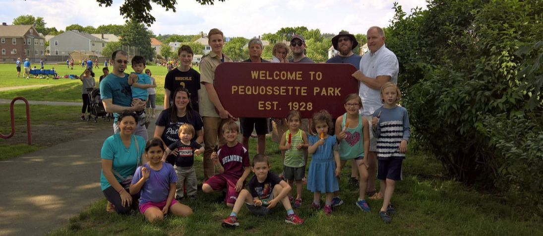 Volunteers hold the PQ Park sign at a spring gathering 2017.